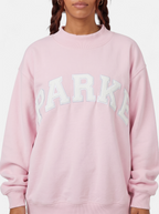Women's purple oversized varsity sweatshirt detail shot